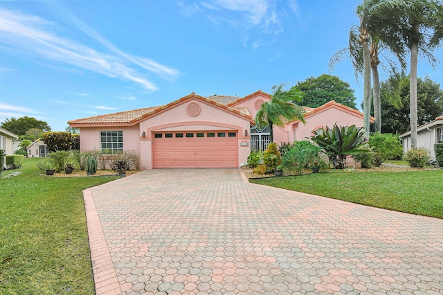 mediterranean / spanish home featuring a garage and a front yard