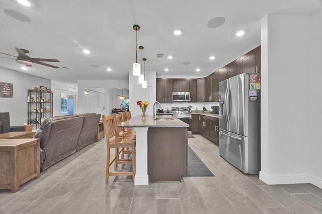 1316 SW Abacus Ave, Port Saint Lucie, FL 34953 - kitchen featuring stainless steel appliances, open floor plan, dark brown cabinetry, ceiling fan, and a sink