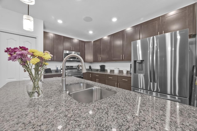 1316 SW Abacus Ave, Port Saint Lucie, FL 34953 - kitchen with appliances with stainless steel finishes, a sink, dark brown cabinetry, stone counters, and recessed lighting