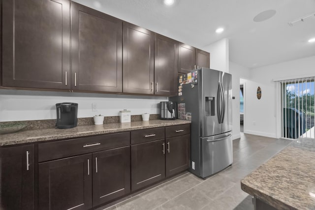 1316 SW Abacus Ave, Port Saint Lucie, FL 34953 - kitchen with stainless steel fridge, dark brown cabinetry, light tile patterned floors, recessed lighting, and baseboards