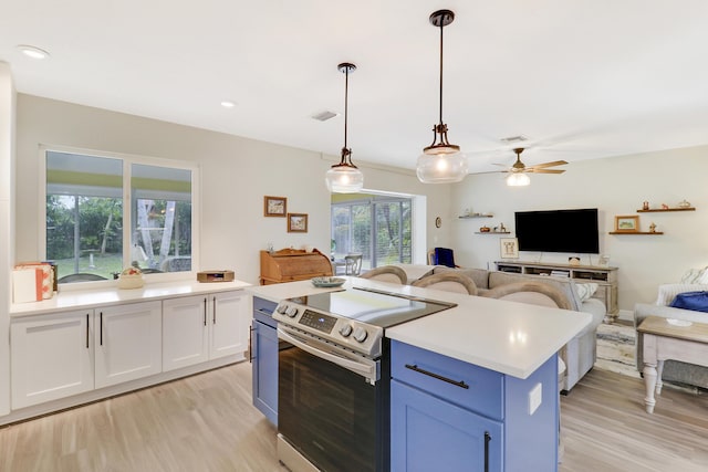 kitchen with light hardwood / wood-style flooring, stainless steel electric range oven, white cabinets, a kitchen island, and decorative light fixtures