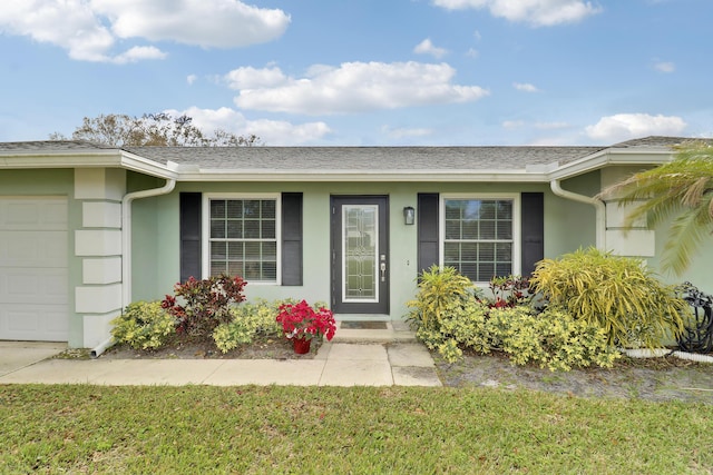 entrance to property with a garage and a yard