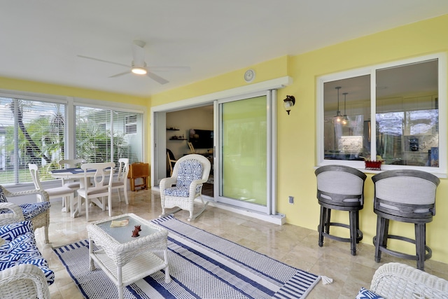 sunroom featuring ceiling fan