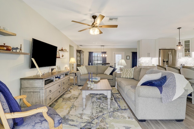 living room with light wood-type flooring and ceiling fan