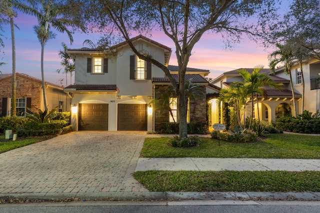 mediterranean / spanish home with a yard and a garage