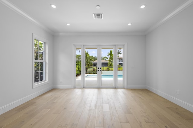 spare room with a wealth of natural light, light hardwood / wood-style floors, and french doors