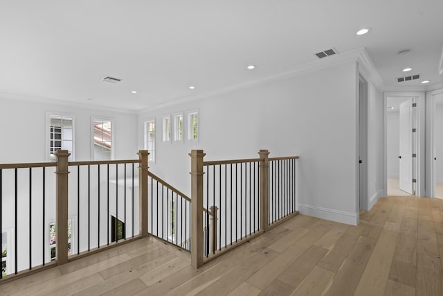 hall with crown molding and light hardwood / wood-style floors