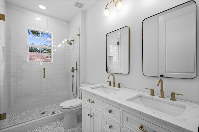 bathroom featuring vanity, toilet, and a shower with shower door