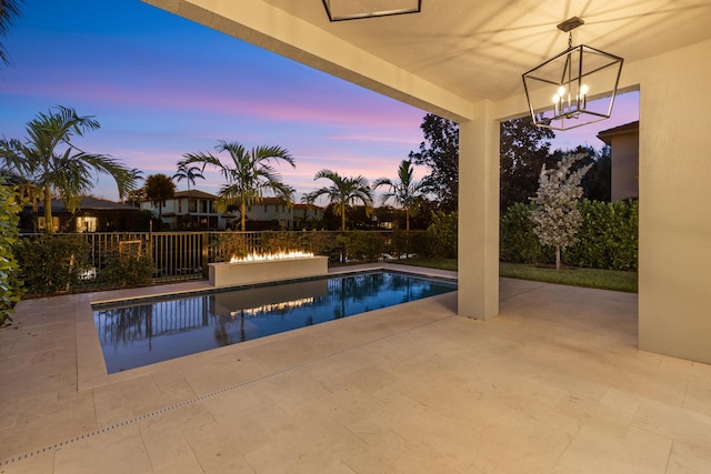 pool at dusk featuring a patio area