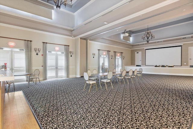 interior space with a towering ceiling, ornamental molding, a chandelier, and hardwood / wood-style flooring