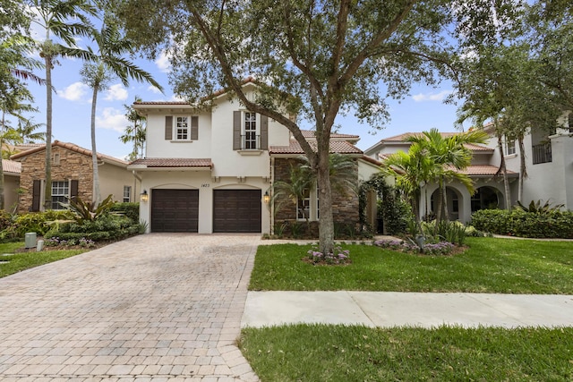 mediterranean / spanish-style home featuring a garage and a front yard