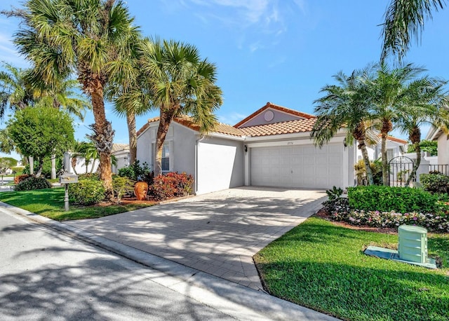 mediterranean / spanish-style house featuring a garage and a front lawn