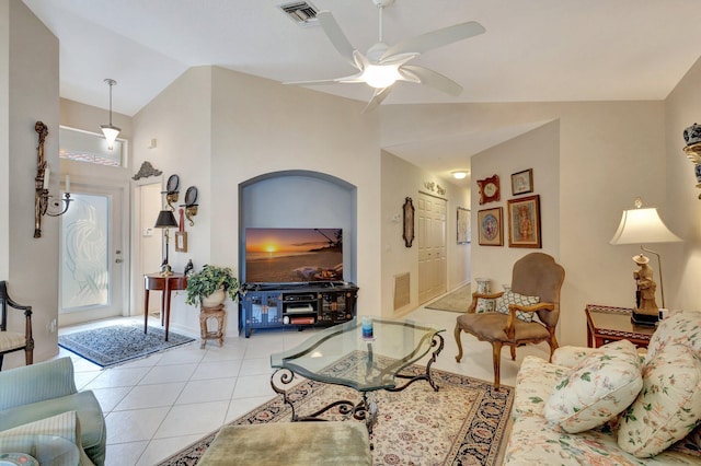 living room featuring light tile patterned floors, lofted ceiling, visible vents, and a ceiling fan