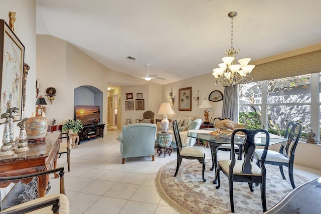 dining space with lofted ceiling, ceiling fan with notable chandelier, light tile patterned flooring, and visible vents