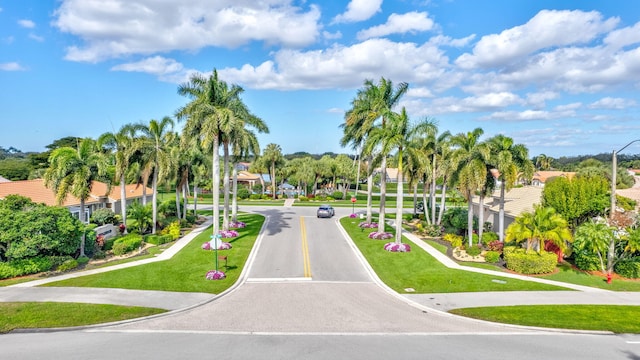 view of community featuring uncovered parking, a lawn, and a residential view