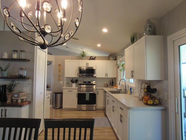 kitchen featuring tasteful backsplash, sink, white cabinets, and appliances with stainless steel finishes