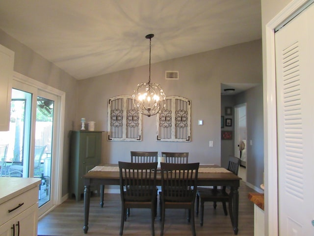 dining room with wood-type flooring, lofted ceiling, and an inviting chandelier