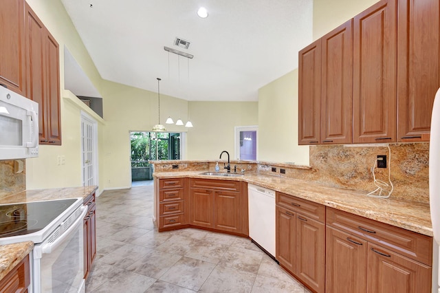 kitchen with sink, white appliances, hanging light fixtures, tasteful backsplash, and kitchen peninsula