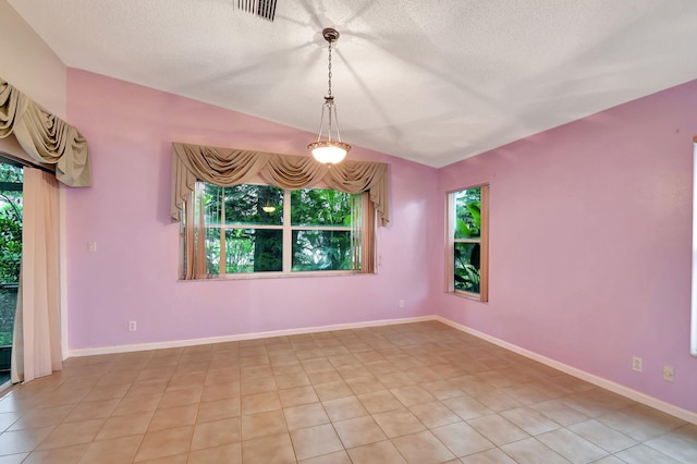 tiled spare room with a textured ceiling