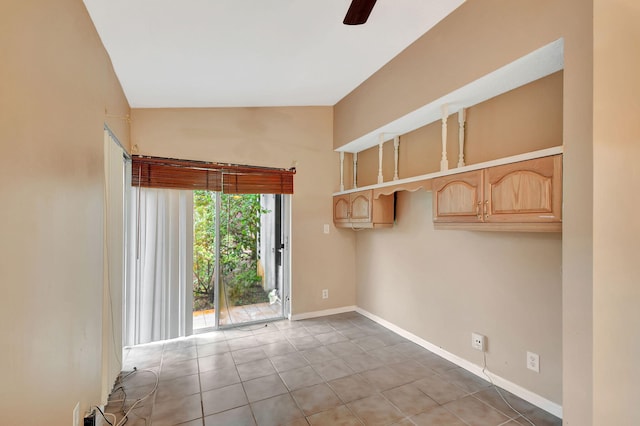 tiled empty room with vaulted ceiling and ceiling fan