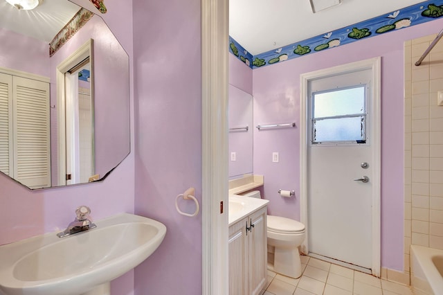 full bathroom with tiled shower / bath, tile patterned floors, toilet, and sink