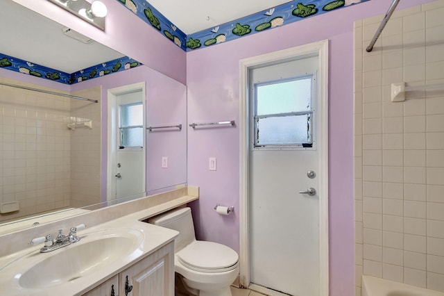 full bathroom with vanity, tiled shower / bath, and toilet