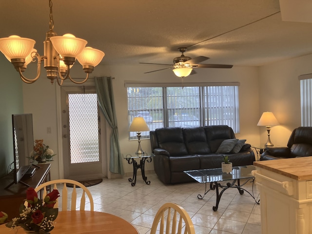 living room with ceiling fan with notable chandelier and light tile patterned floors