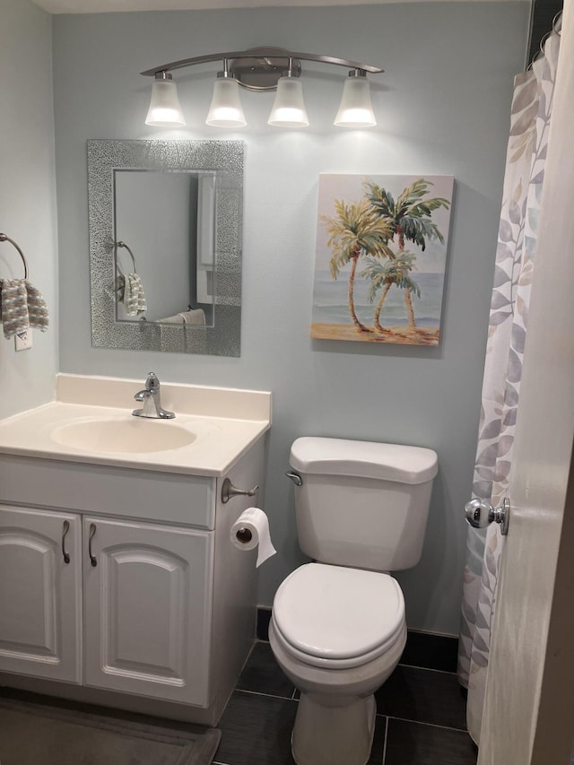 bathroom featuring tile patterned flooring, vanity, and toilet