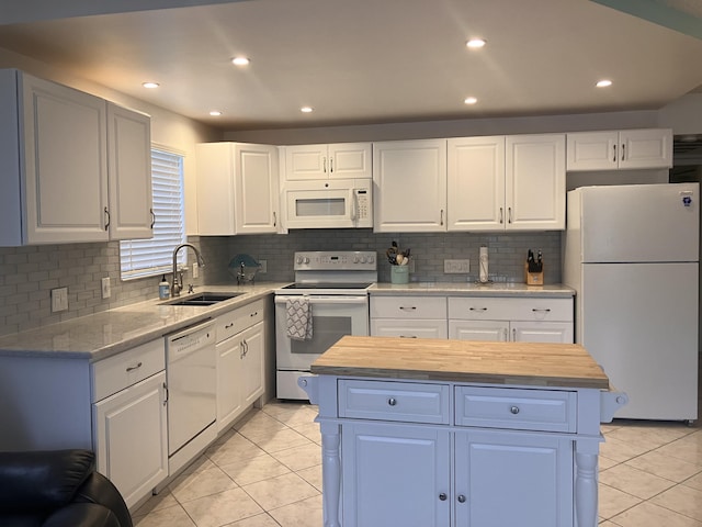 kitchen with butcher block counters, sink, white appliances, and white cabinetry