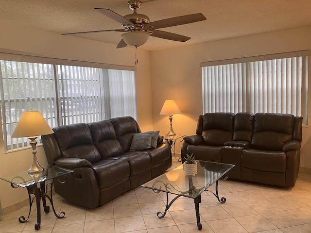 tiled living room with ceiling fan and a textured ceiling