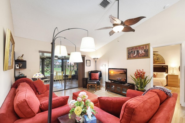 living room featuring vaulted ceiling, ceiling fan, and light wood-type flooring