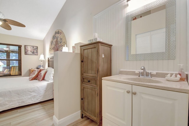 bathroom featuring hardwood / wood-style flooring, ceiling fan, lofted ceiling, and vanity