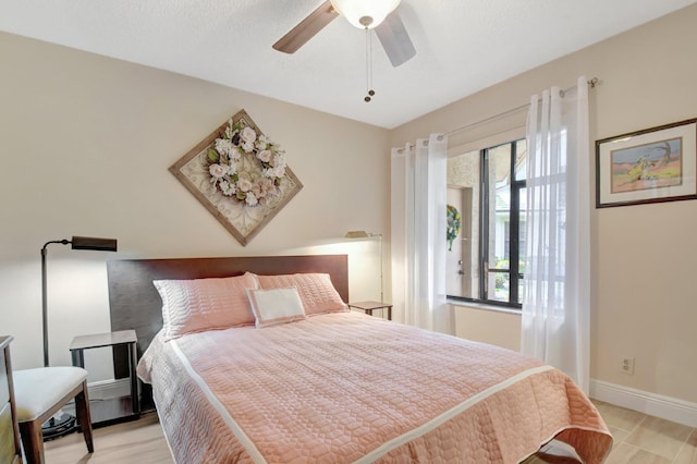 bedroom with multiple windows, ceiling fan, and light wood-type flooring