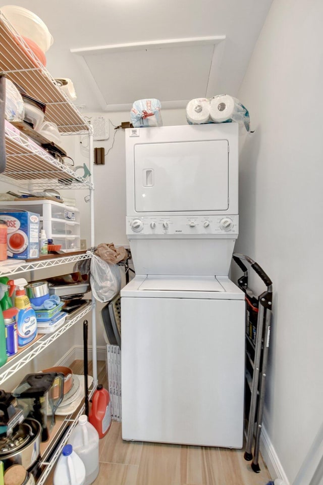 washroom with stacked washer and dryer and light wood-type flooring