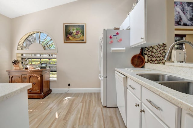 kitchen with sink, white cabinetry, vaulted ceiling, white dishwasher, and backsplash