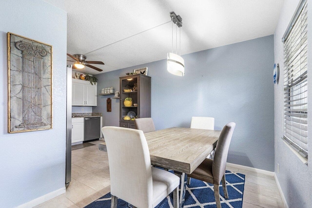 dining space featuring ceiling fan, light tile patterned flooring, and a textured ceiling