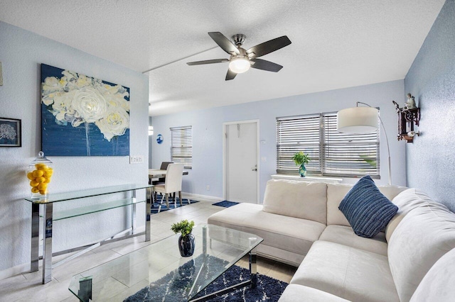 living room with ceiling fan and a textured ceiling