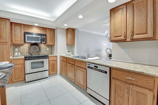 kitchen with sink, crown molding, light stone counters, appliances with stainless steel finishes, and decorative backsplash