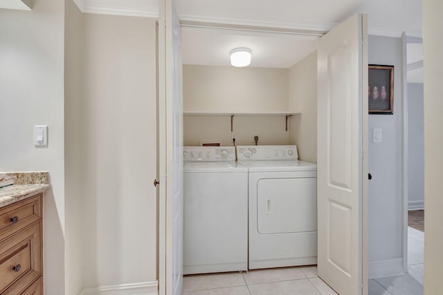 laundry area with washer and clothes dryer and light tile patterned floors