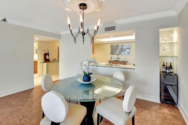 dining room with ornamental molding, parquet flooring, sink, and a notable chandelier