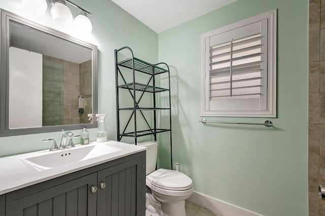 bathroom with vanity, toilet, tile patterned flooring, and a tile shower