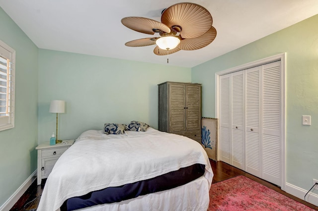 bedroom featuring dark wood-type flooring, a closet, and ceiling fan