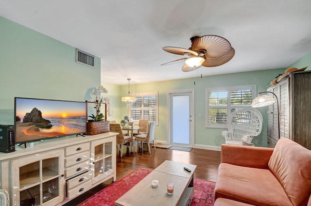 living room featuring dark wood-type flooring and ceiling fan