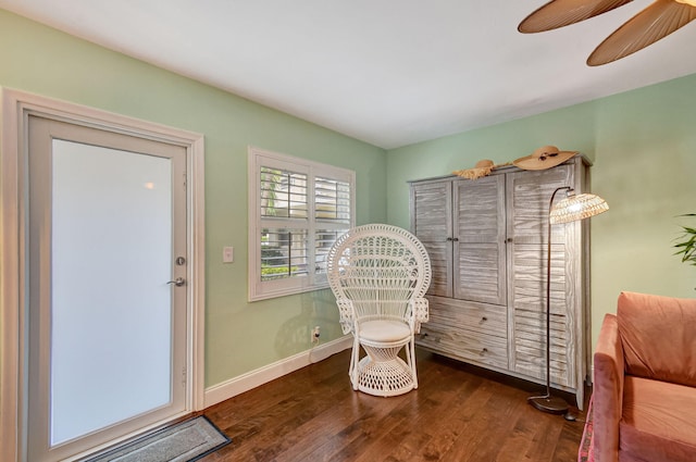 sitting room with dark wood-type flooring and ceiling fan