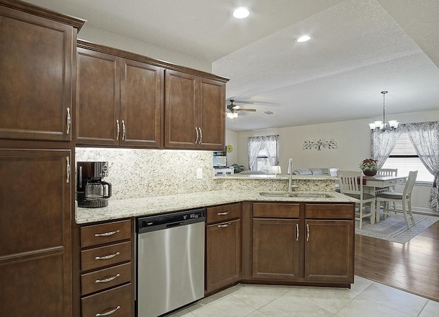 kitchen featuring a sink, plenty of natural light, a peninsula, and stainless steel dishwasher