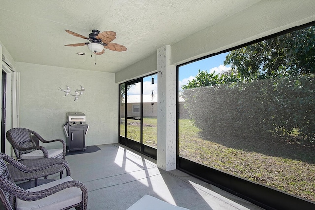 sunroom / solarium featuring a ceiling fan