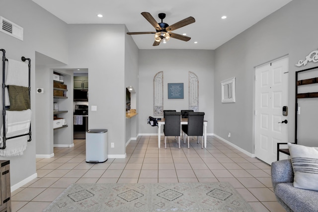 tiled home office with ceiling fan and a high ceiling