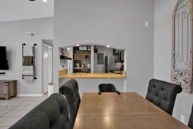 tiled dining space with built in shelves and a high ceiling