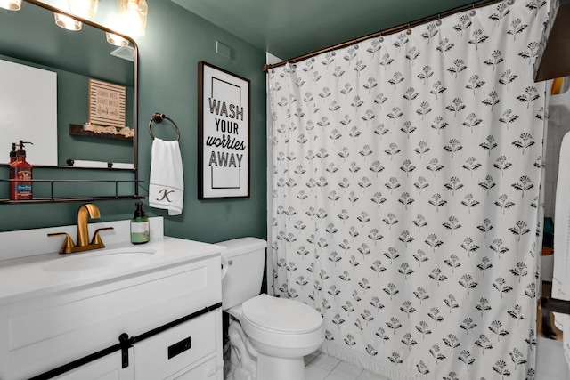 bathroom featuring tile patterned flooring, vanity, toilet, and walk in shower