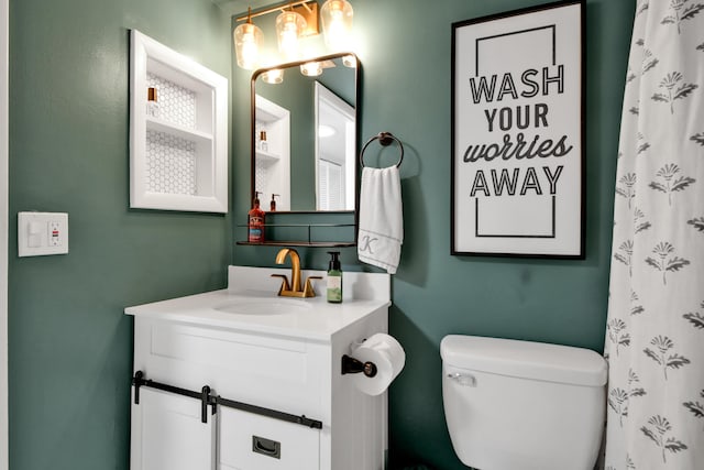 bathroom featuring vanity, walk in shower, and toilet